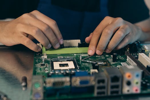 Close-up of hands assembling electronic components on a motherboard in a tech setting.